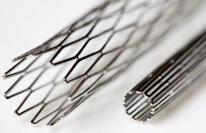 One result of medical nitinol processing is a stent; pictured are two stents made of medical-grade nitinol, one compressed and the other expanded.