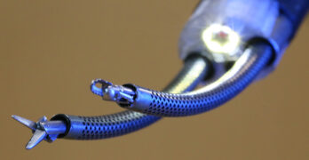A photo of an endoscopic robot's curved arms with instruments at the end.